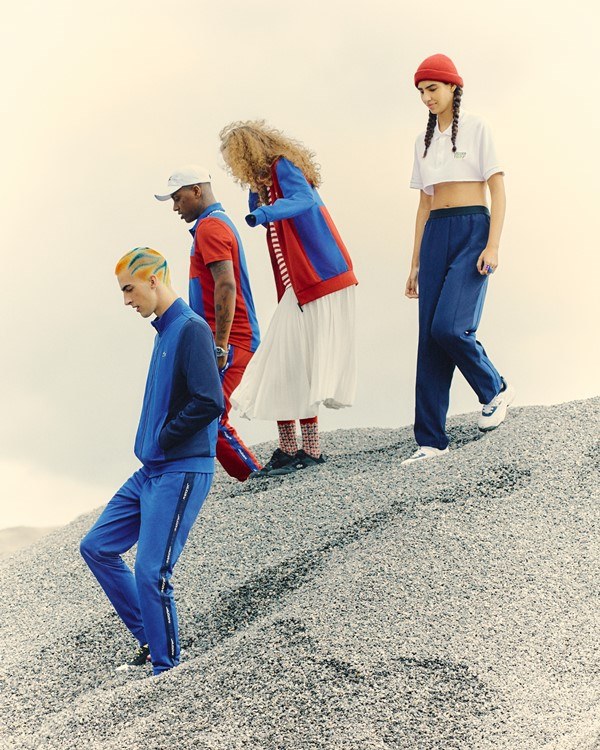 Jovens posando para foto em um morro. Eles estão usando roupas da marca Lacoste.