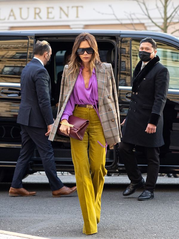 Mulher branca com blazer caminhando na rua