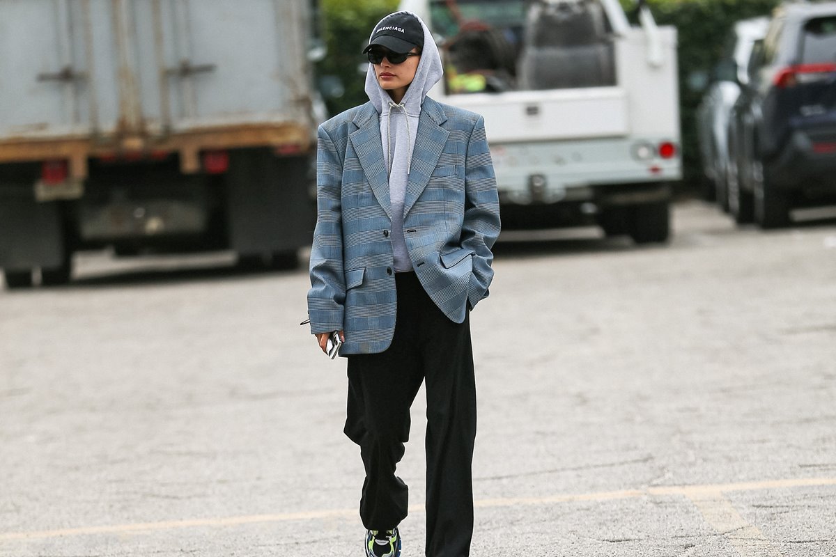 Mulher branca com blazer caminhando na rua