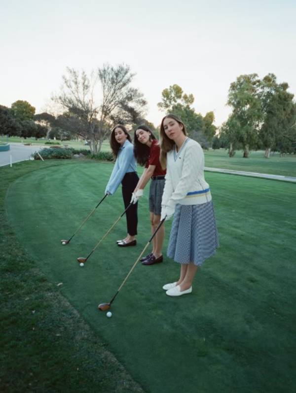 Irmãs da banda Haiam jogando golfe em foto para a W Magazine