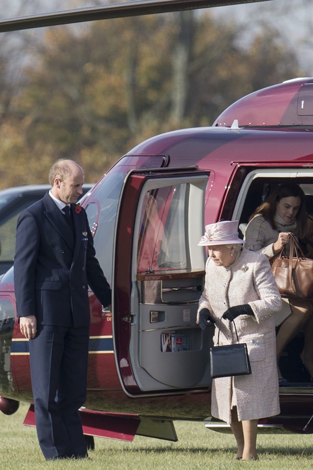 Foto colorida. Rainha Elizabeth desce de um helicóptero