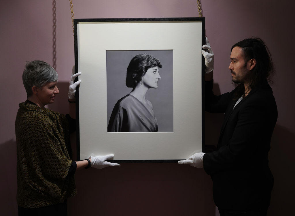 Os conservadores históricos do Palácio Real Ola Ruiz-Aguillo e Nelson Garcia manuseando um retrato de Diana, Princesa de Gales, feito pelo fotógrafo David Bailey em 1988