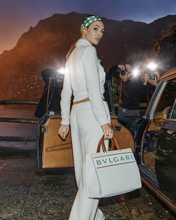 Modelo entrando em carro segurando bolsa da Bulgari com a Casablanca