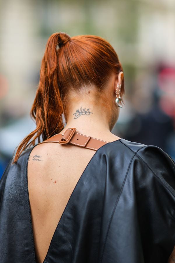 Mulher branca com blusa preta na rua