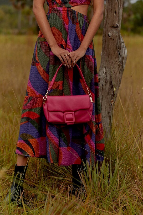 Na imagem com cor, bolsa e vestido em destaques na coleção da Renner