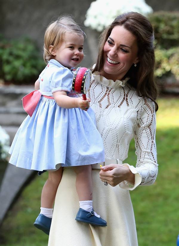 Mulher branca com filha em jardim