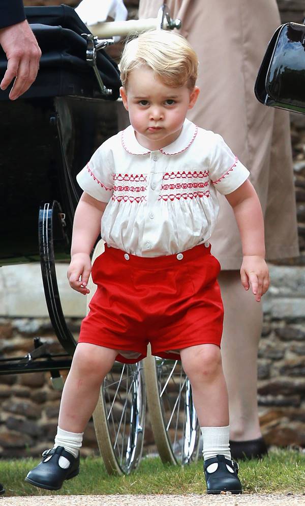 Criança branca andando com shorts vermelho 