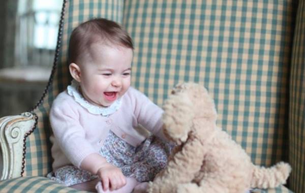 Bebê sorrindo ao segurar um urso de pelúcia