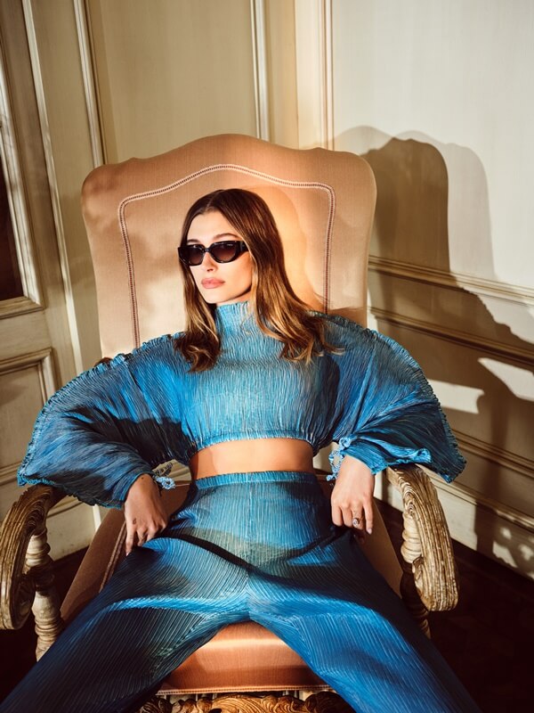 Na imagem com cor, a modelo Haily Bieber posa com conjunto azul para a campanha da Vogue Eyewear 