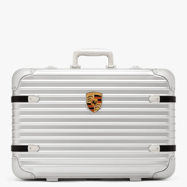 Na imagem em preto e branco, modelo utiliza a nova mala da Rimowa com a Porsche 