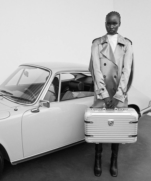 Na imagem em preto e branco, modelo utiliza a nova mala da Rimowa com a Porsche 