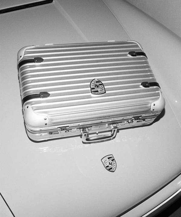 Na imagem em preto e branco, modelo utiliza a nova mala da Rimowa com a Porsche 