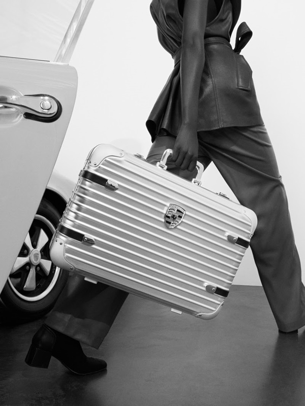 Na imagem em preto e branco, modelo utiliza a nova mala da Rimowa com a Porsche 