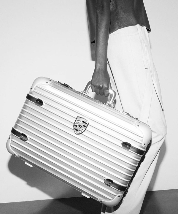 Na imagem em preto e branco, modelo utiliza a nova mala da Rimowa com a Porsche 