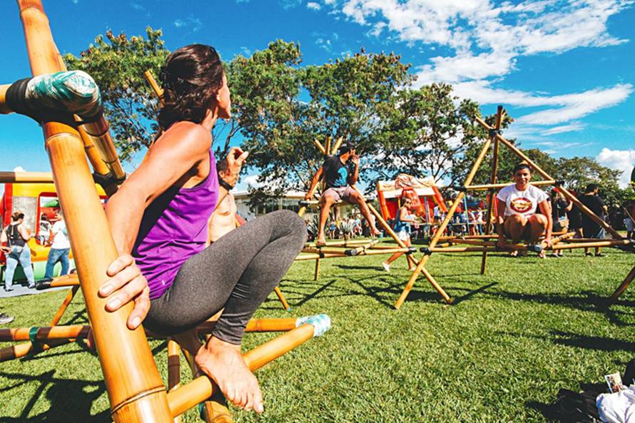 Menina branca em cima de um brinquedo de bambu