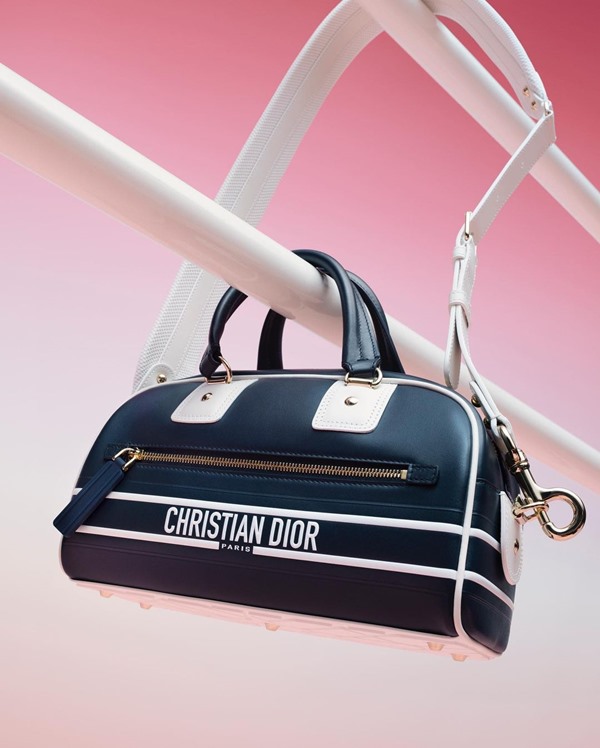 Bolsa preta com listras brancas nas extremidades e a logo da marca Dior.