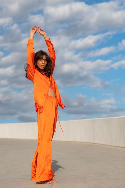 Modelo de cabelo médio e franja usa conjunto laranja brilhante