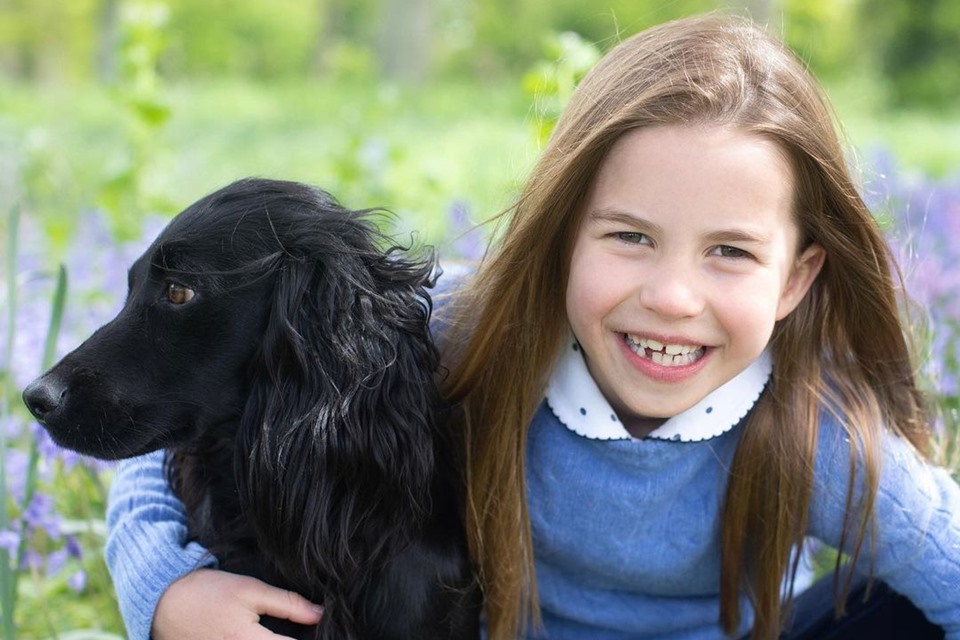 Foto colorida. Princesa Charlotte com um cachorro