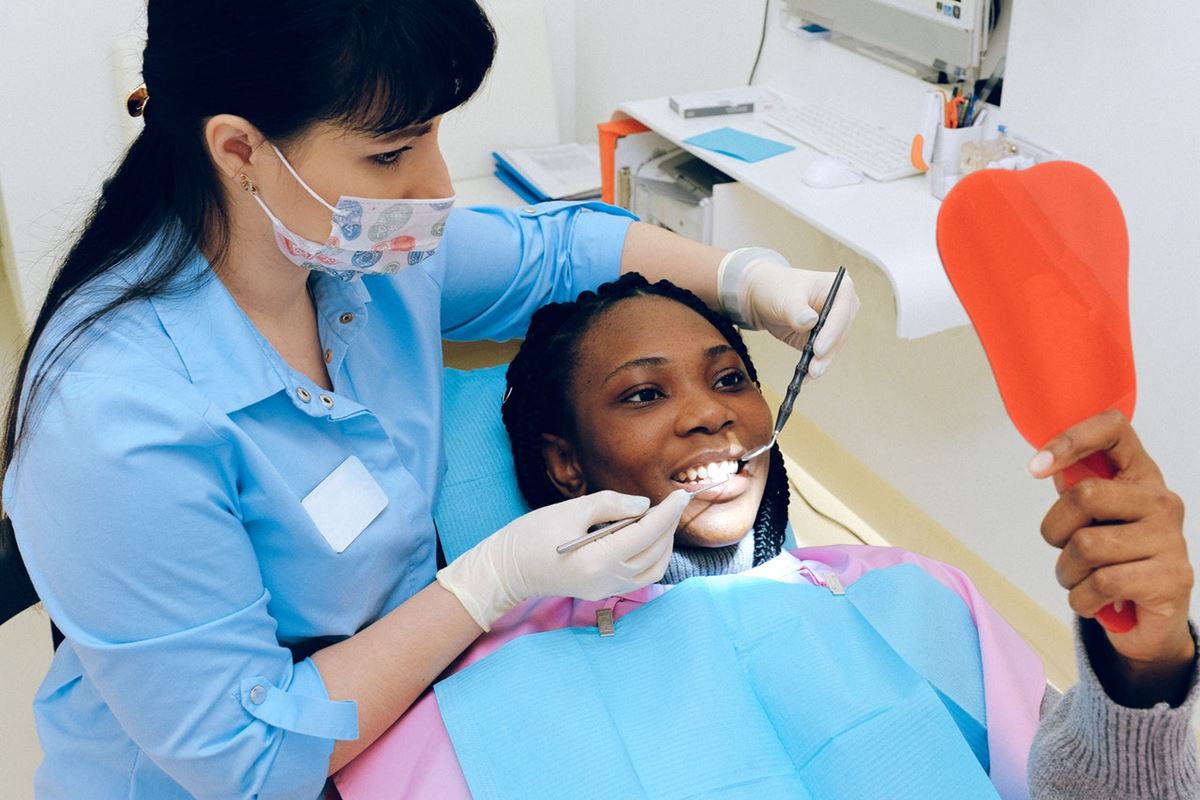 Dentista atendendo paciente em consultório