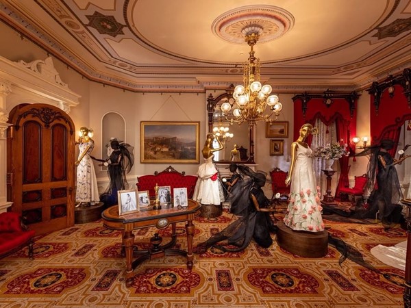 Sala com decoração e móveis do século 18 e manequins vestindo roupas de época. A sala faz parte da exposição In America: An Anthology of Fashion, em cartaz no Metropolitan Museum of Art, em Nova York