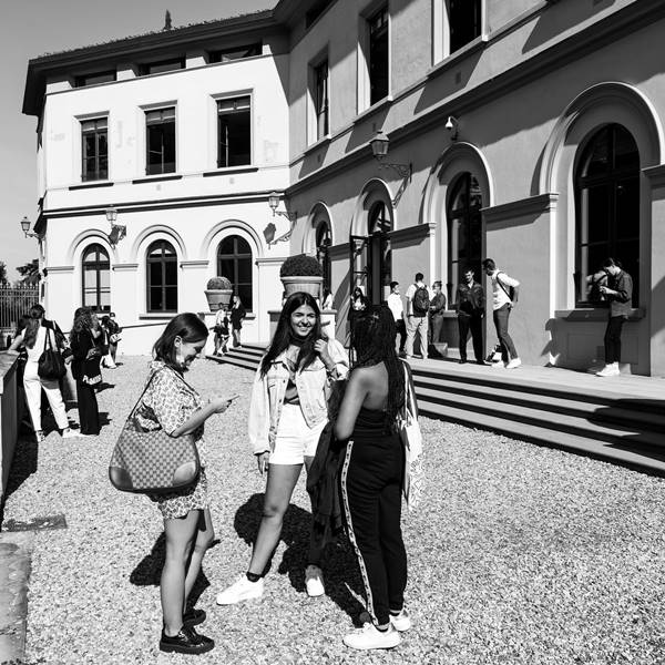 Estudantes parada em frente a uma escola 