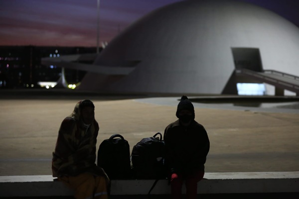 Frio em Brasília. Termômetros registraram a mais baixa temperatura da história do DF. Na foto, pessoas sentada em uma para de ônibus com casacos, gorros e luvas.