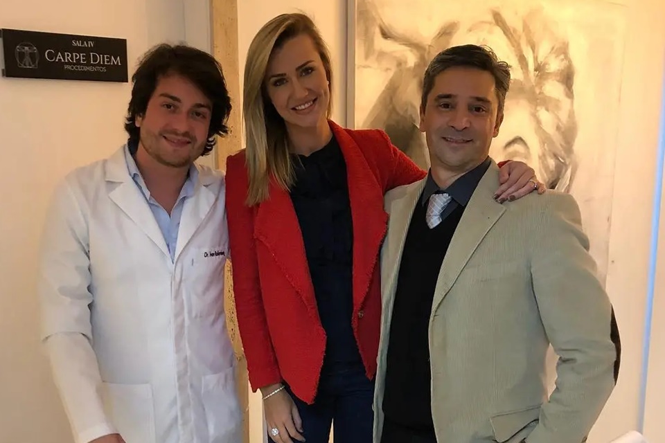 Foto colorida. Ana Paula Siebert Justus entre os médicos Ivan Rollemberg e Fernando Macedo