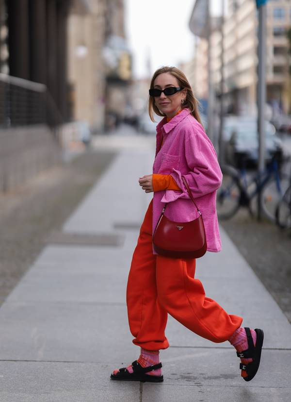 Look com camisa rosa, calça vermelha e papete preta