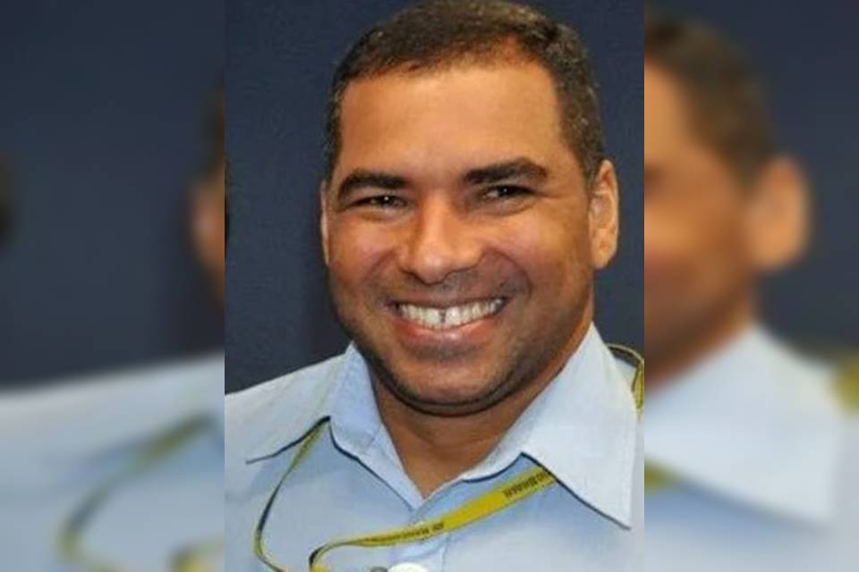 homem de camisa azul sorrindo para uma foto