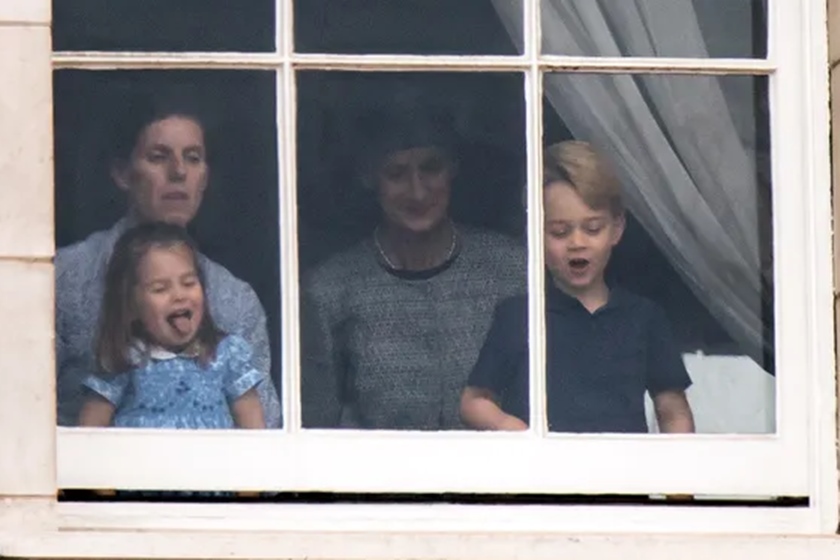 Foto colorida. Princesa Charlotte e príncipe George na janela