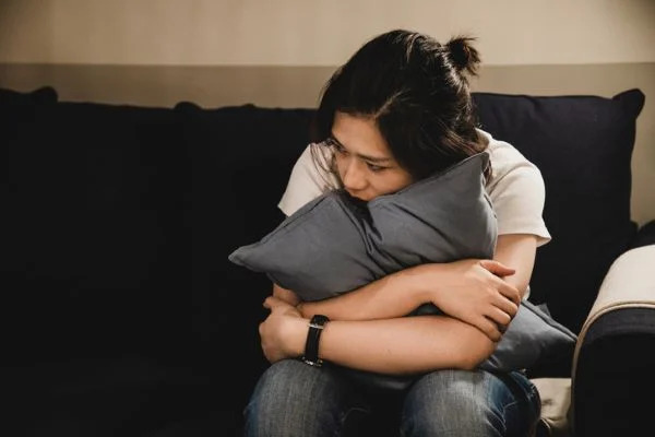 Foto de uma mulher abraçando o travesseiro
