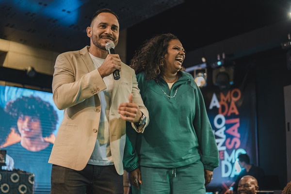 Evento Top Cufa, um concurso de beleza, que aconteceu no Distrito Federal. Na foto, é possível ver os apresentadores da festa: um homem branco e jovem, com um blazer bege, e uma mulher negra com cabelos cacheados longos de moletom verde.