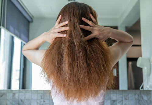 Mulher de costas mostrando o cabelo ressecado