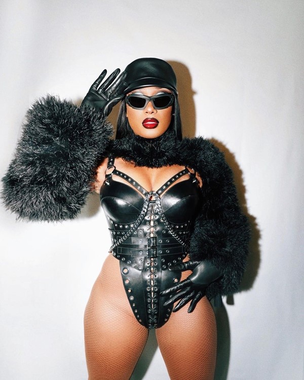 Na imagem com cor, Megan Thee Stallion posa com óculo de sol preto