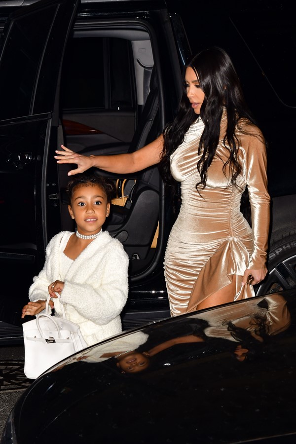 Na imagem com cor, Kim Kardashian sai do carro ao lado de North West