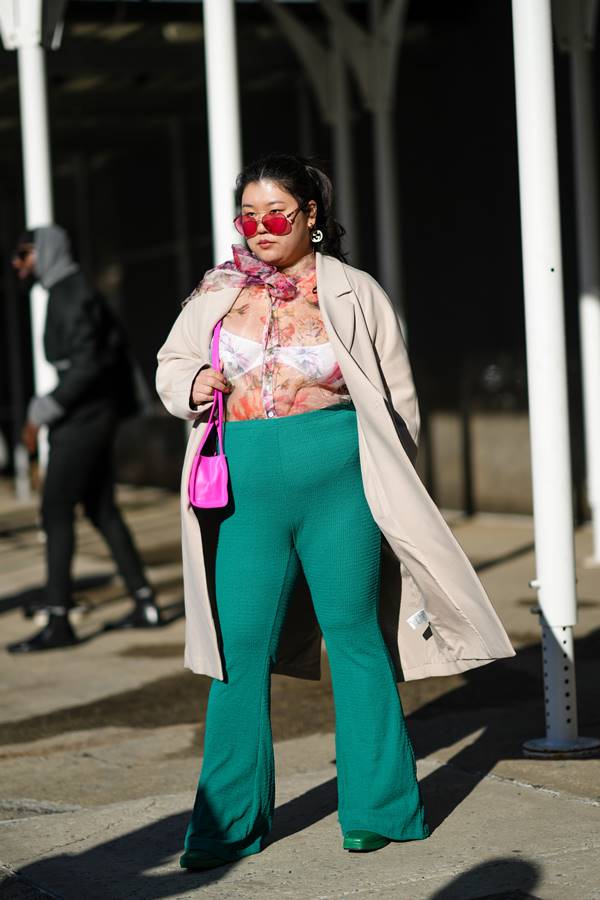 Mulher com calça verde e blusa florida 