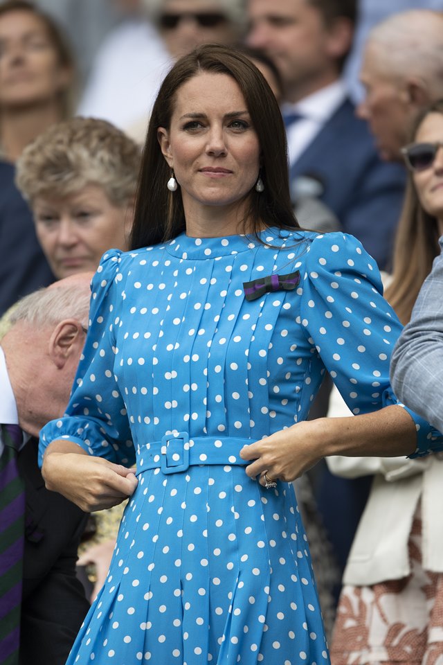 Foto colorida. Mulher de vestido de poá azul