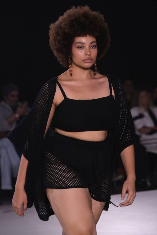 Na passarela da Renner, modelo usa look preto com cropped e short com transparência