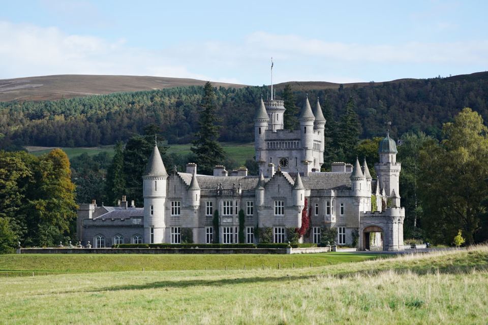 Foto colorida. Construção de um castelo rodeado por área verde