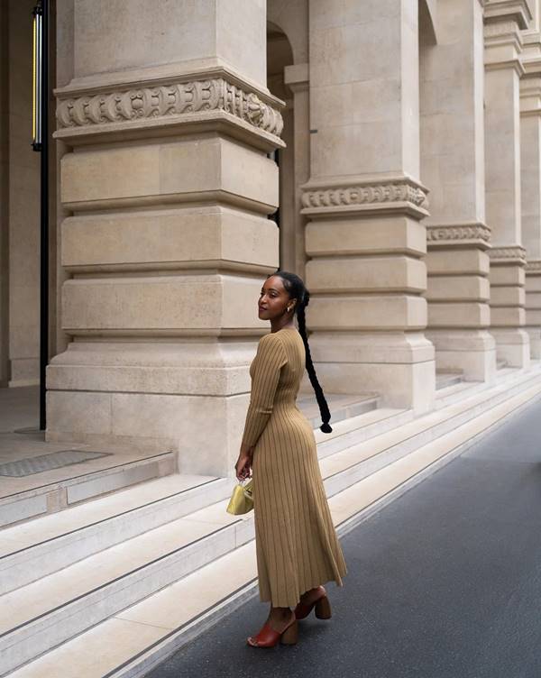 Mulher francesa usando vestido longo com salto alto 