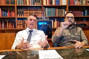 O então presidente Jair Bolsonaro ao lado de intérprete numa live