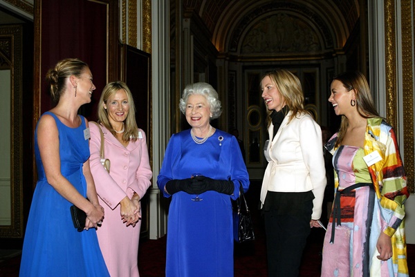 A rainha Elizabeth em um encontro com outras personalidades britânicas no ano de 2004. Ela usa um vestido azul royal de mangas longas e luvas pretas. Na foto também está presente as modelos Kate Moss e Heather Mills-McCartney, além da escritora J. K. Rowling e a cantora Charlotte Church