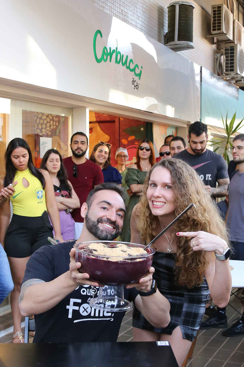 Foto colorida de várias pessoas comendo açai - Metrópoles