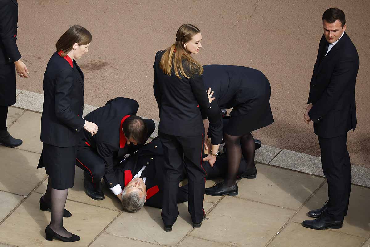 Um funcioUm funcionário do Palácio de Buckingham desmaia do lado de fora do Palácio de Buckingham depois de prestar seus respeitos durante o Funeral de Estado da Rainha Elizabeth II em 19 de setembro de 2022 em Londres, Inglaterra. Elizabeth Alexandra Mary Windsor nasceu em Bruton Street, Mayfair, Londres, em 21 de abril de 1926. Ela se casou com o príncipe Philip em 1947 e subiu ao trono do Reino Unido e da Commonwealth em 6 de fevereiro de 1952 após a morte de seu pai, o rei George VI. A rainha Elizabeth II morreu no Castelo de Balmoral, na Escócia, em 8 de setembro de 2022, e é sucedida por seu filho mais velho, o rei Carlos IIInário doméstico do Palácio de Buckingham desmaia do lado de fora do Palácio de Buckingham depois de prestar seus respeitos durante o Funeral de Estado da Rainha Elizabeth II em 19 de setembro de 2022 em Londres, Inglaterra. Elizabeth Alexandra Mary Windsor nasceu em Bruton Street, Mayfair, Londres, em 21 de abril de 1926. Ela se casou com o príncipe Philip em 1947 e subiu ao trono do Reino Unido e da Commonwealth em 6 de fevereiro de 1952 após a morte de seu pai, o rei George VI. A rainha Elizabeth II morreu no Castelo de Balmoral, na Escócia, em 8 de setembro de 2022, e é sucedida por seu filho mais velho, o rei Carlos III