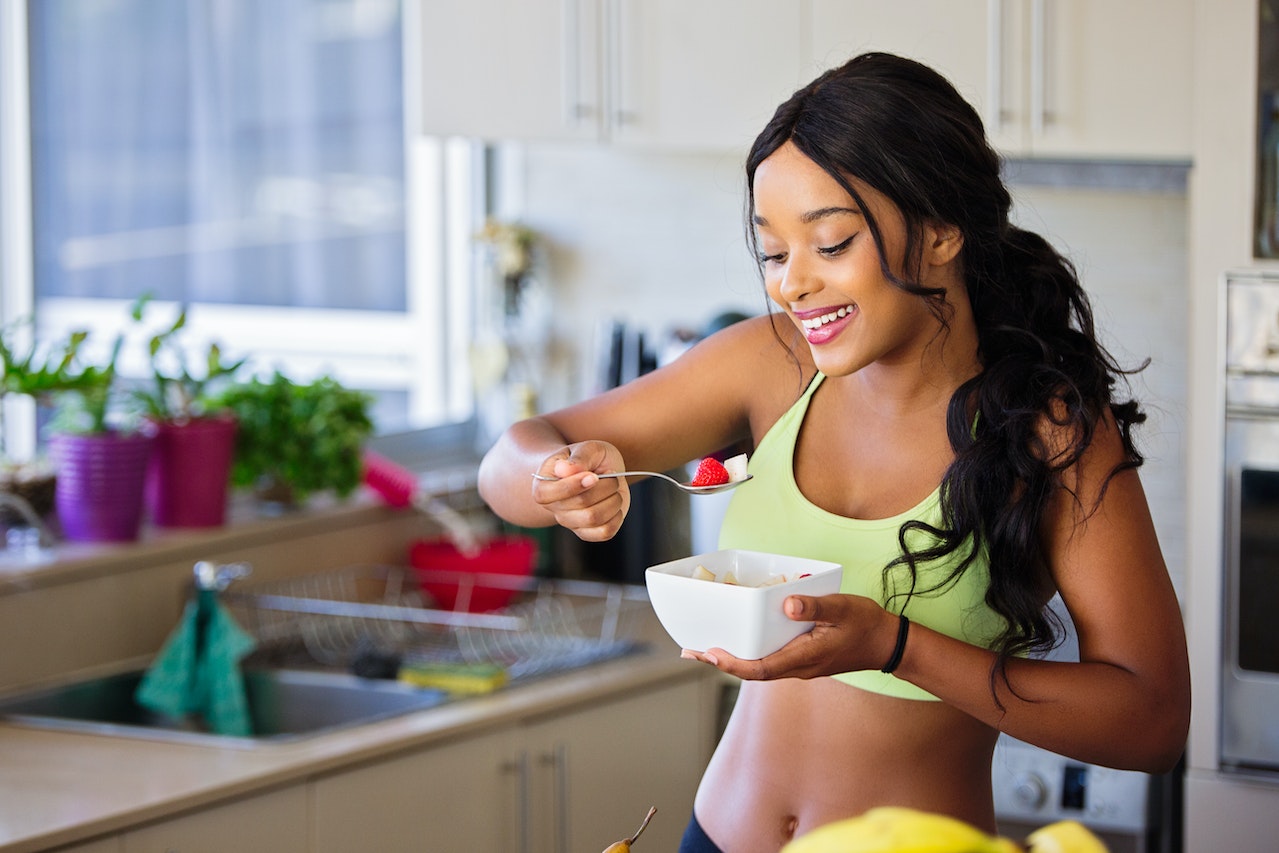 Alimentação e dieta equilibrada. Mulher comendo frutas em um bowl - Metrópoles 