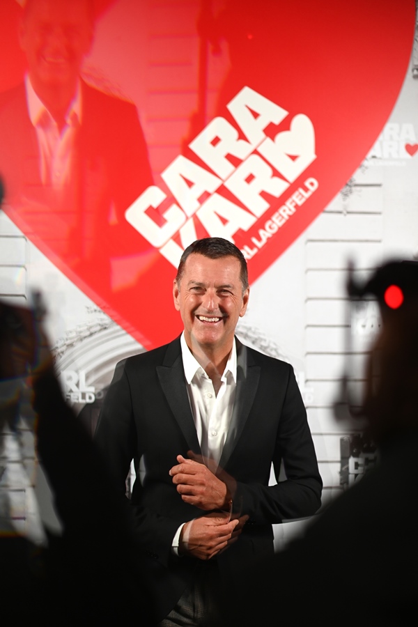 Pier Paolo Righi, executivo-chefe da etiqueta Karl Lagerfeld, em evento de lançamento de coleção da marca. Ele é um homem branco, de meia idade, com cabelo castanho curto. Veste uma camisa branca de botão e um terno cinza.