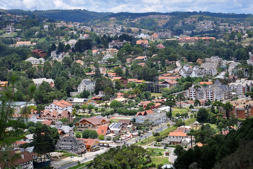 Vista de uma cidade pequena com montanhas ao fundo - Metrópoles