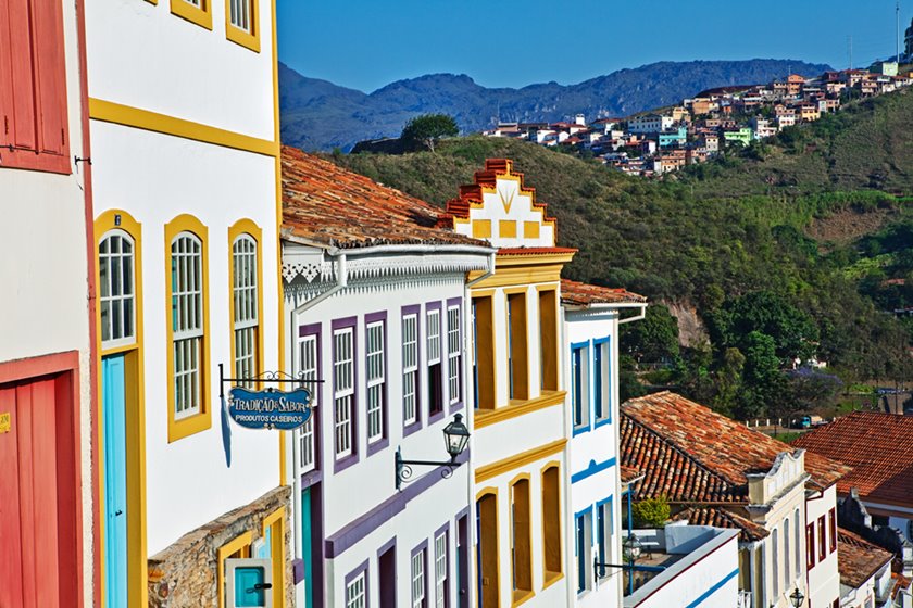 Casas em estilo colonial com montanhas ao fundo - Metrópoles