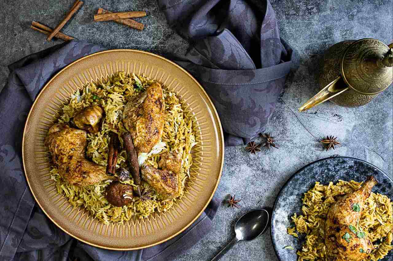 Na foto, um pato com arroz e frango em um fundo cinza - Metrópoles