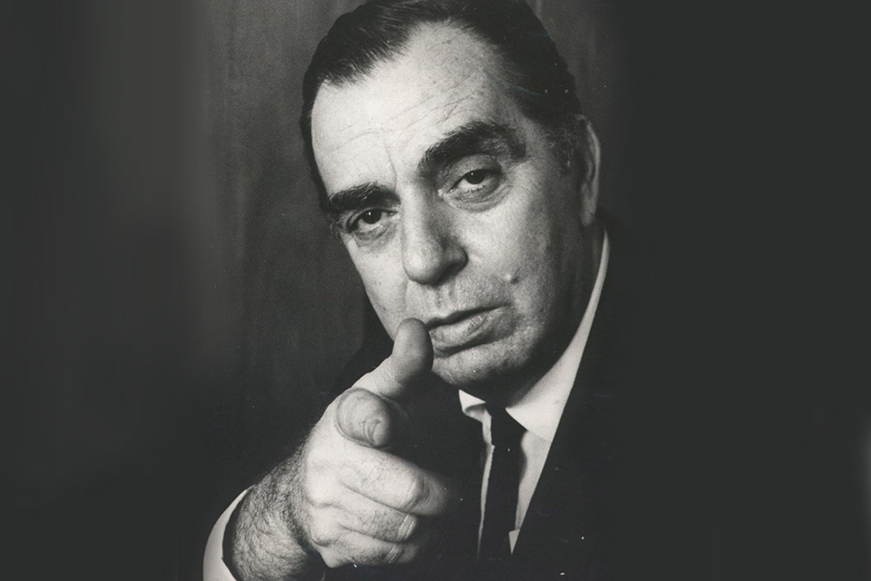 O escritor brasileiro Nelson Rodrigues em foto posada preta e branca. Ele olha para a câmera e aponta com o dedo indicador - Metrópoles